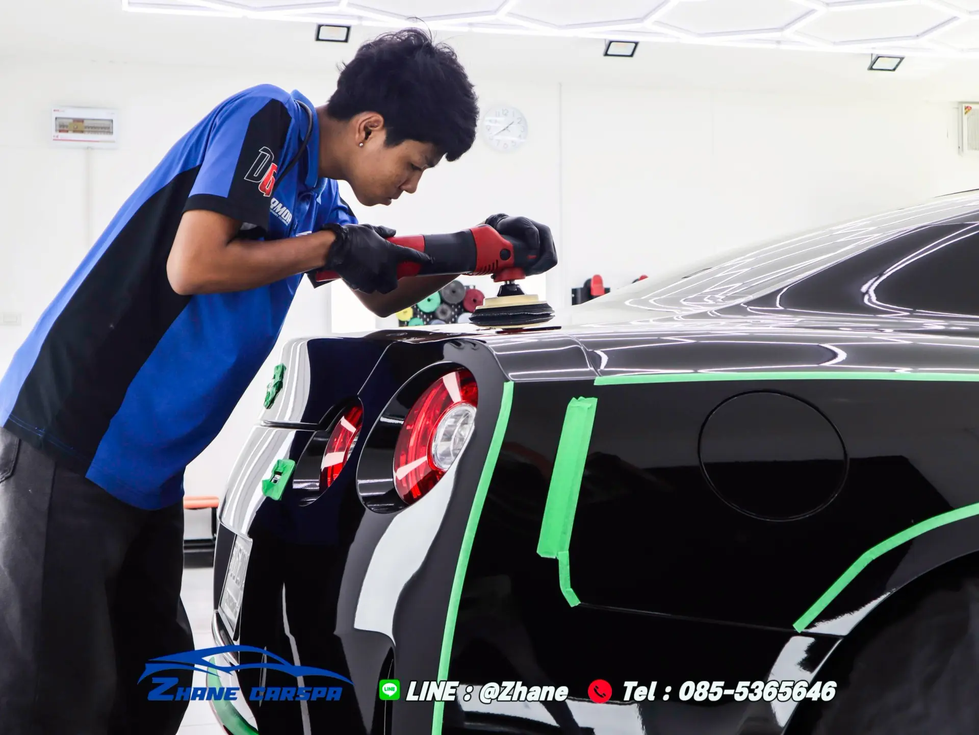 ช่างกำลังใช้เครื่องขัดสีขัดปรับสภาพผิวสีบริเวณซุ้มล้อหลังรถสปอร์ต Nissan GT-R R35 สีดำ ในขั้นตอน Paint Correction