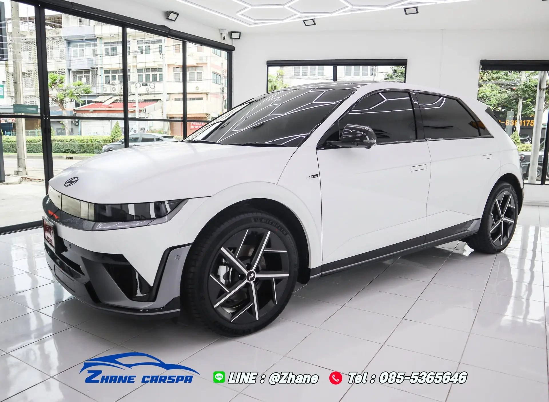 Hyundai IONIQ 5 N Line สีขาวหลังติดฟิล์มกันรอยแบบด้าน จอดในห้องรับรถของ Zhane Car Spa มุมสามส่วนสี่ด้านหน้า