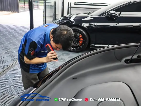 ช่างใช้เครื่องมือติดตั้งฟิล์มกันรอยบริเวณซุ้มล้อและบังโคลนหน้า MG IM6 อย่างละเอียด