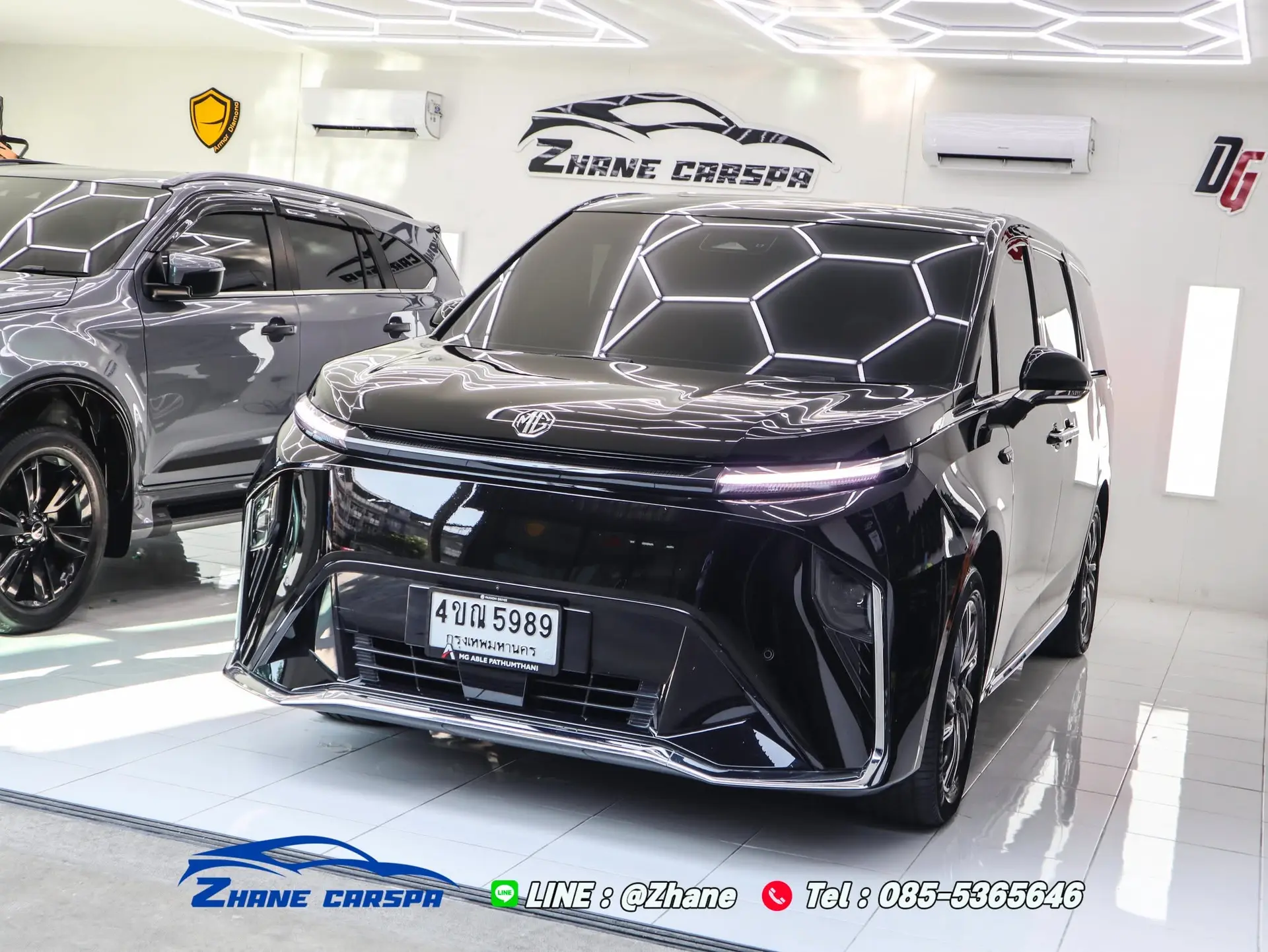 MG Maxus 9 สีดำด้านหน้ารถหลังจบเซอร์วิสรอบ 6 เดือน สะท้อนแถบไฟตรวจงานในสตูดิโอของ Zhane Car Spa